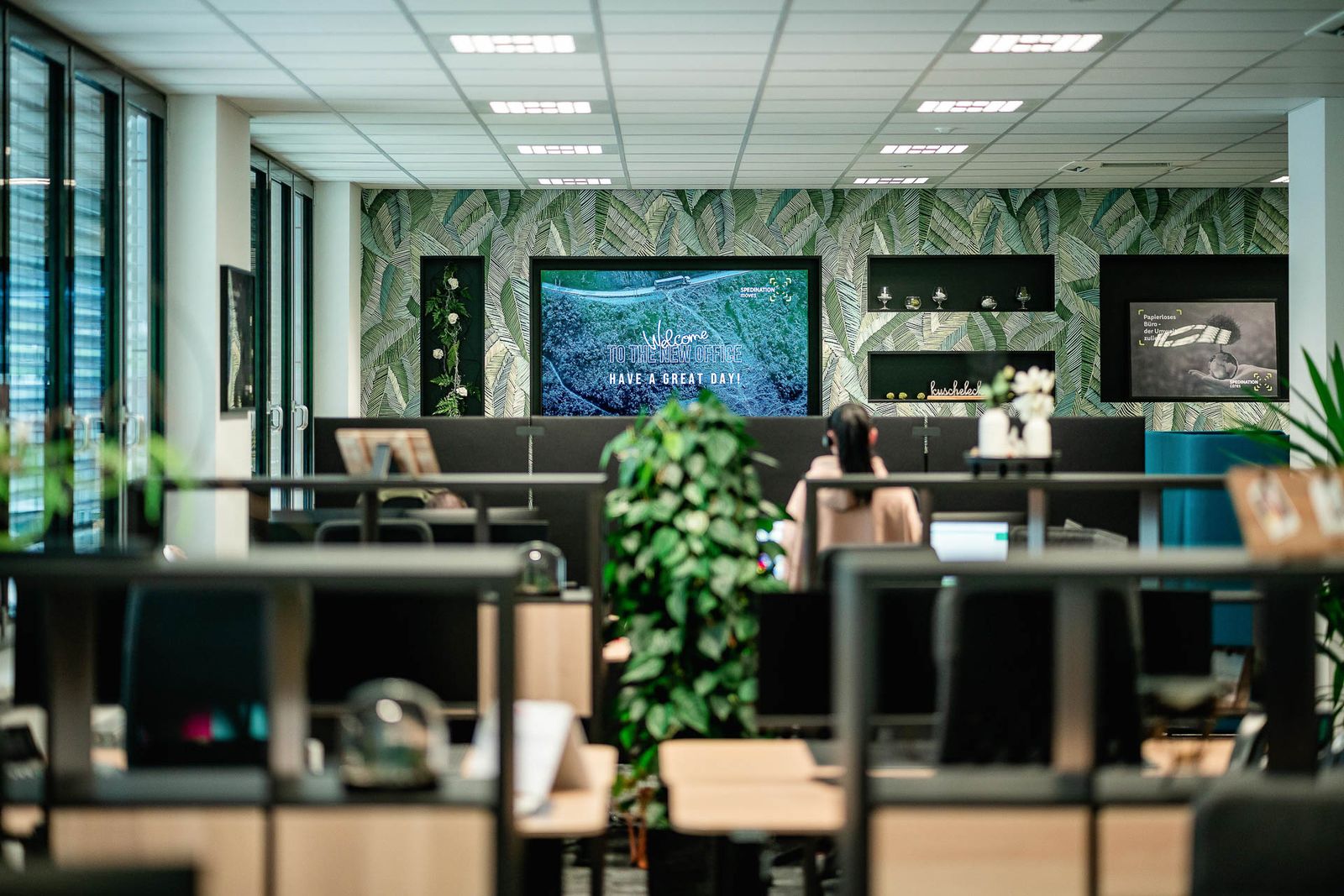 Stimmungsvoller Arbeitsplatz mit Pflanzen, natürlichem Licht und botanischer Wandgestaltung