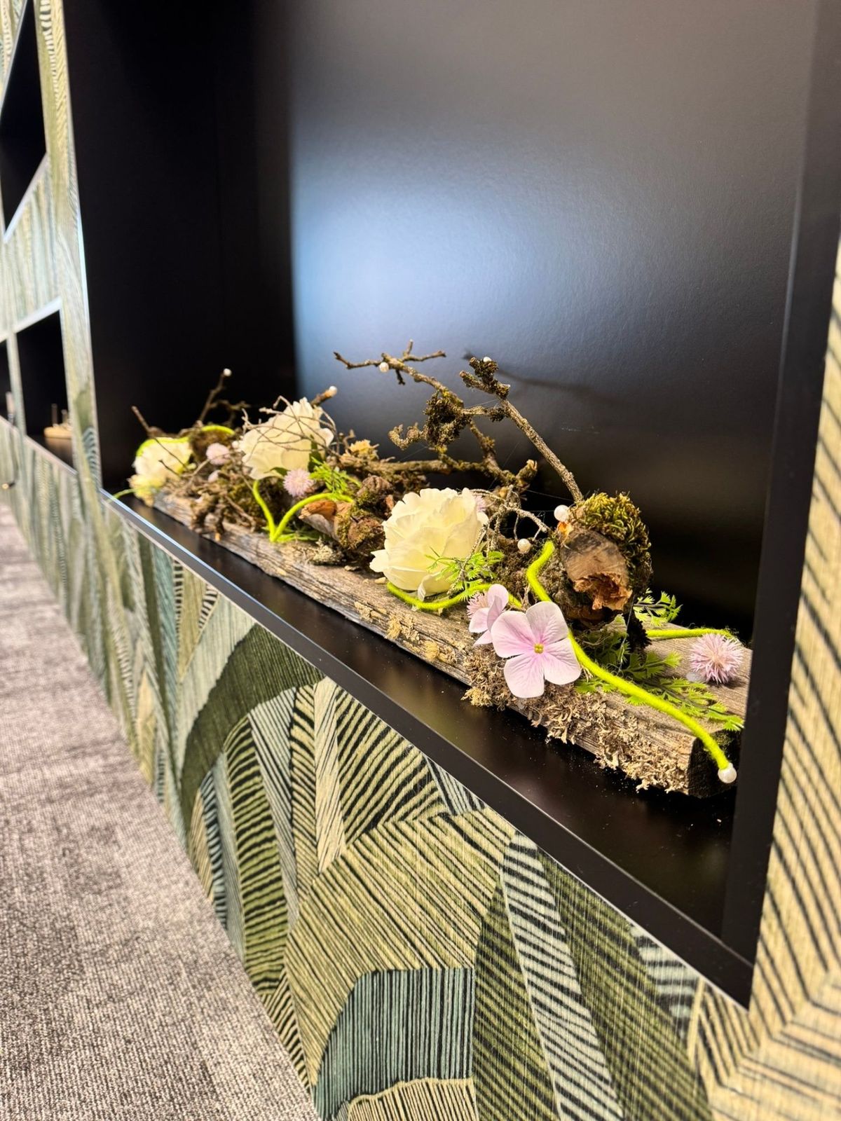 Botanisches Arrangement auf verwittertem Holz