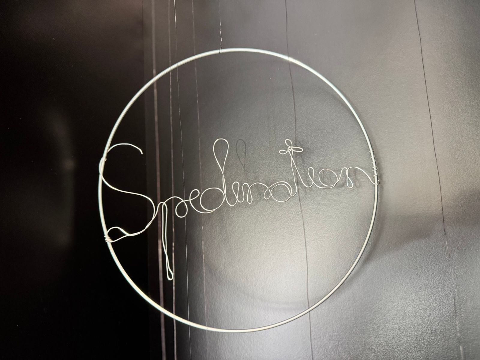 Filigrane Drahtkunst-Installation mit geschwungenem Schriftzug